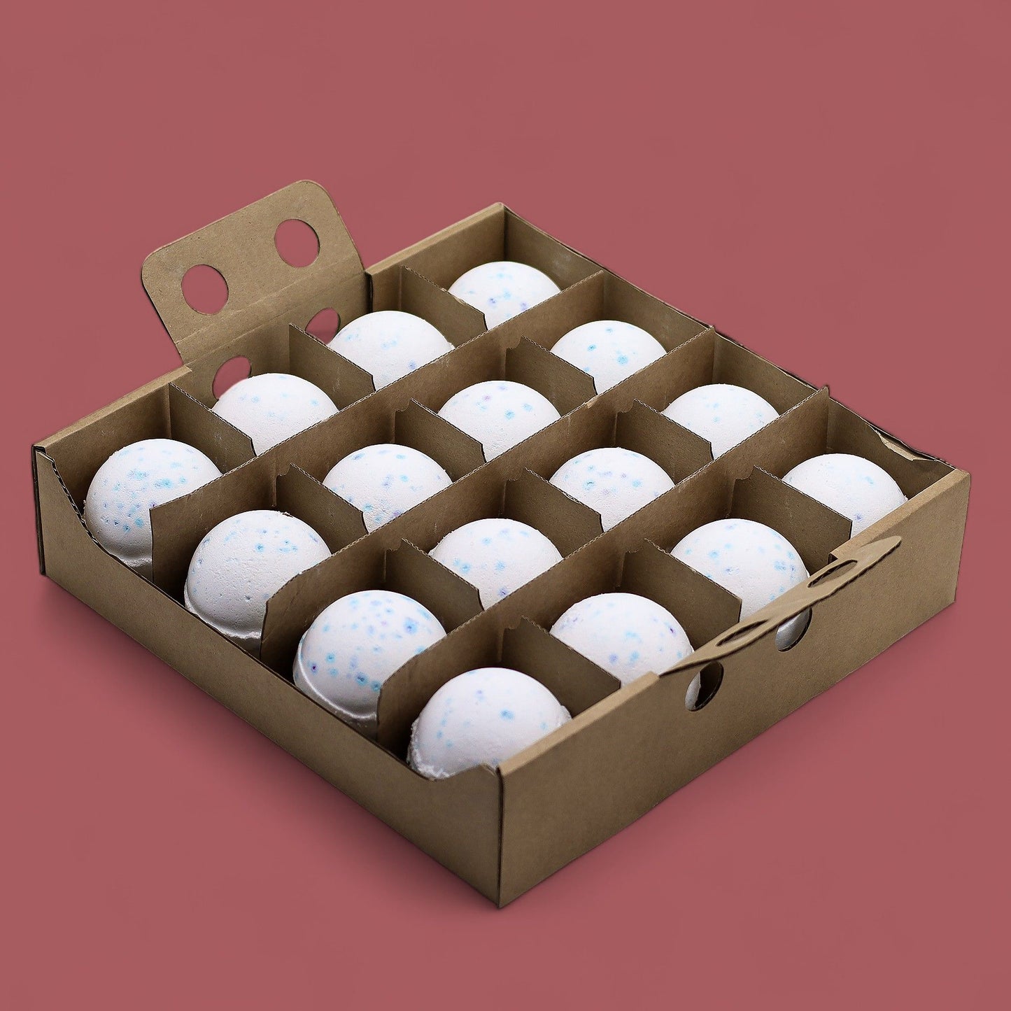 A cardboard display box holding 16 individually wrapped 180g white and blue speckled Ocean bath bombs.