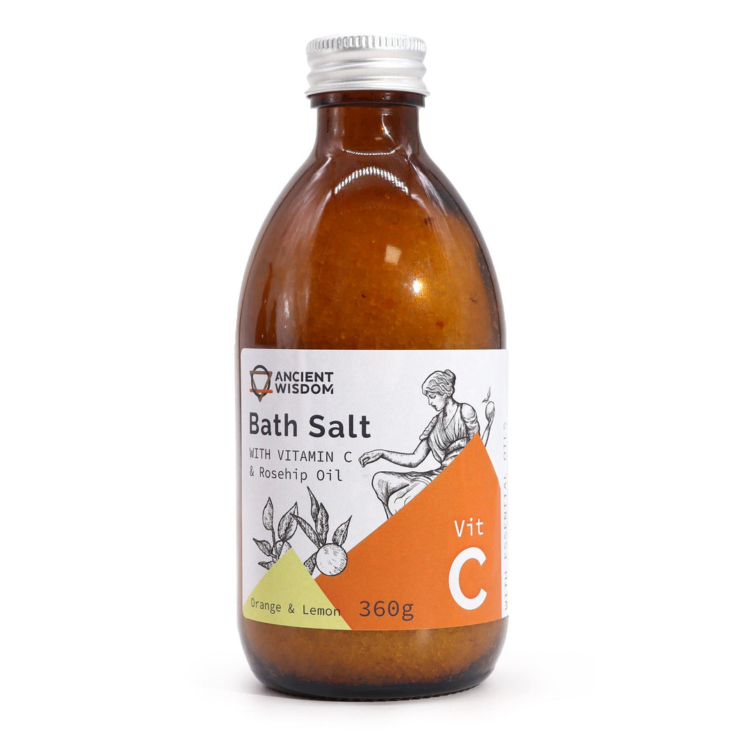 A clear apothecary-style bottle filled with 360g of orange-hued Vitamin C bath salts featuring a luxury "Ancient Goddess" label.