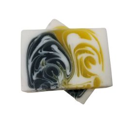 A 115g handcrafted soap slice featuring contrasting dark and light layers for a striking visual design.