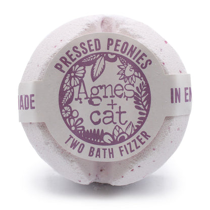 A large, round white bath fizzer wrapped in clear film with a sophisticated purple and white floral label.