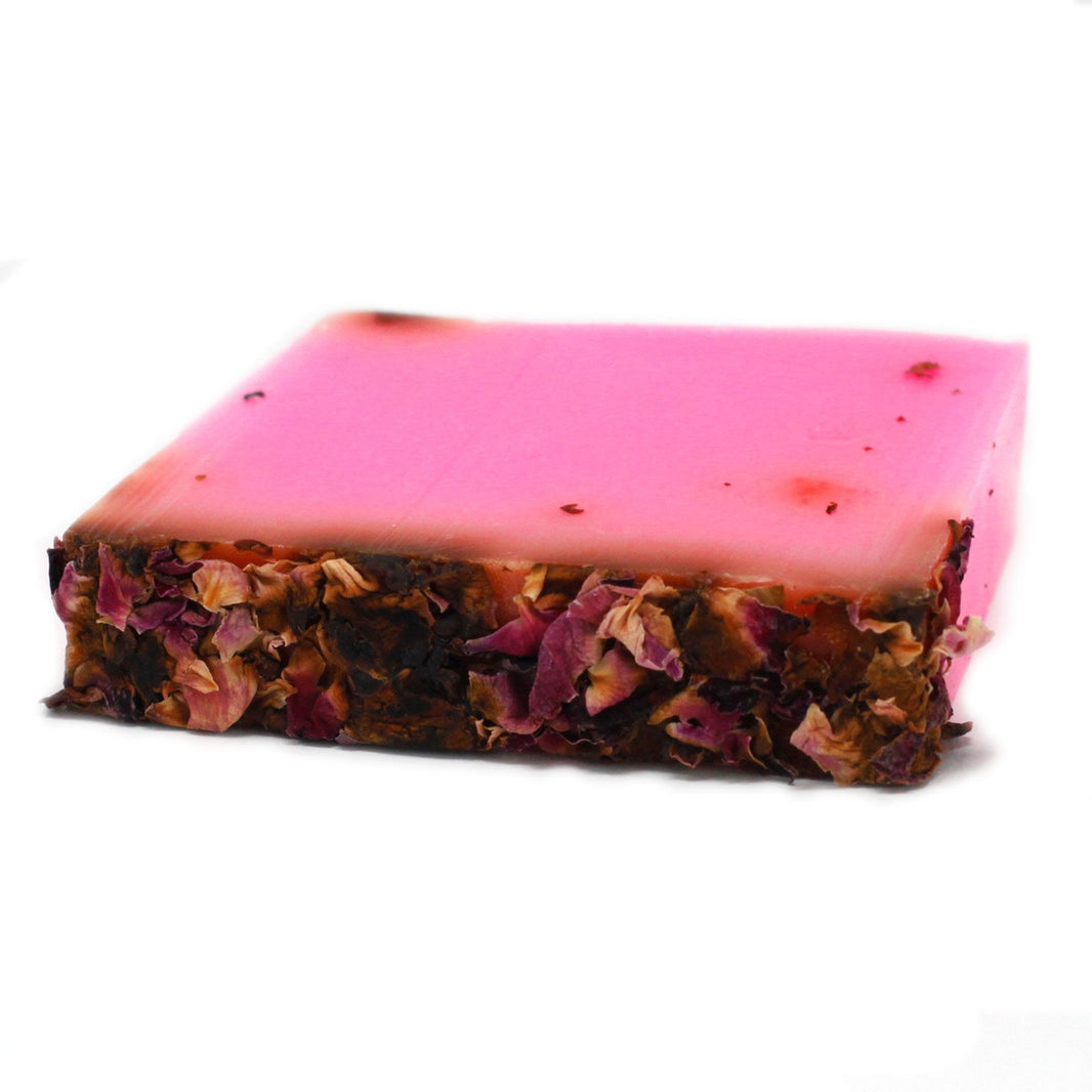A 100g artisan soap bar with a deep pink color, topped with a generous layer of real dried red rose petals.