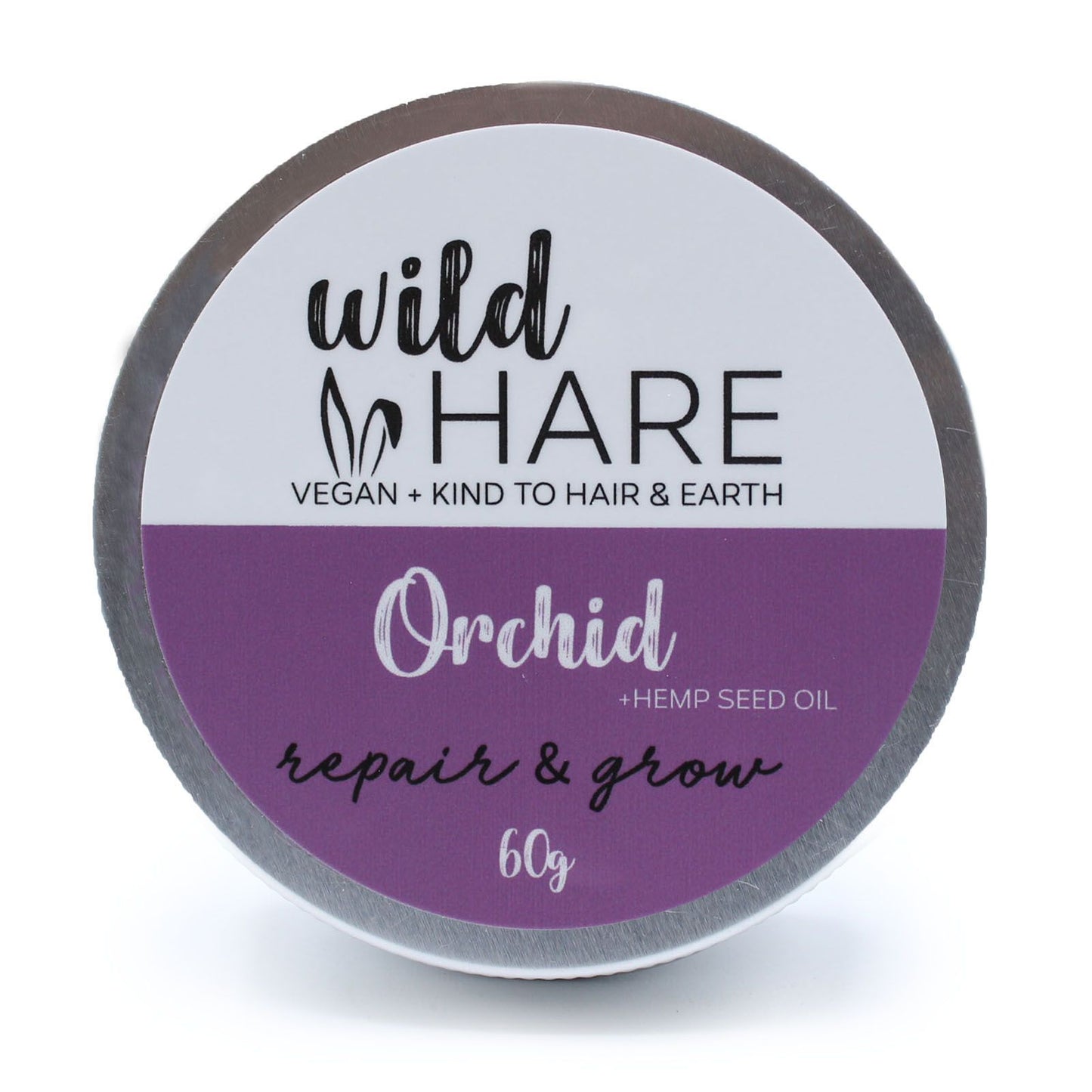 A 60g Wild Hare solid shampoo bar with a purple floral orchid label, stored in a reusable metal travel tin.