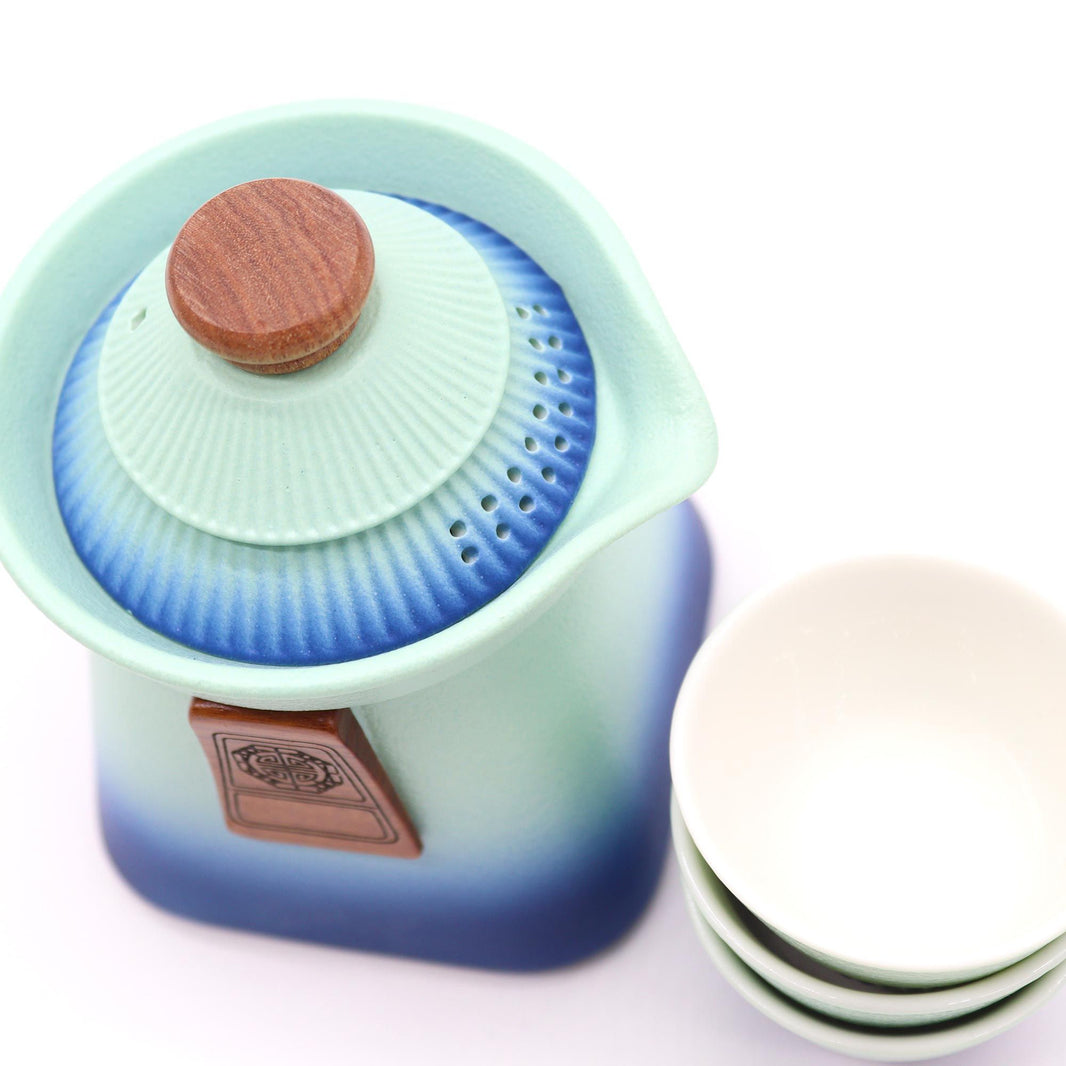 A soft blue matte-finish ceramic teapot set featuring three matching cups in a minimalist, modern design.