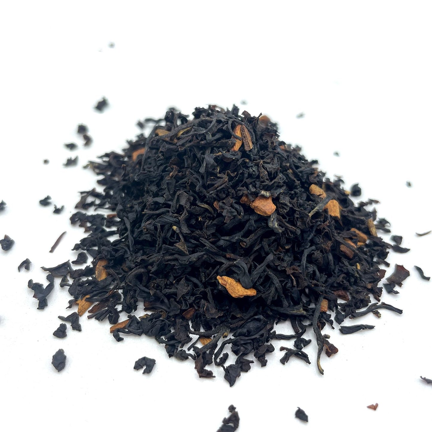 A large pile of organic black tea leaves mixed with fragrant pieces of real dried cinnamon bark for a spicy infusion.