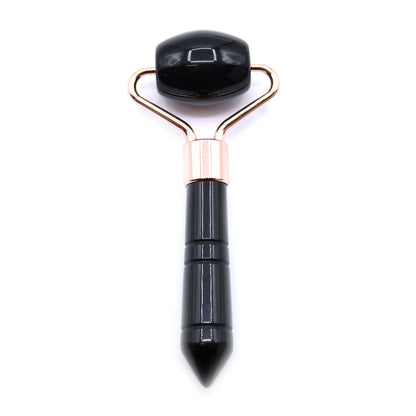 A sleek, handheld facial massage roller featuring a polished, dark black obsidian gemstone head.