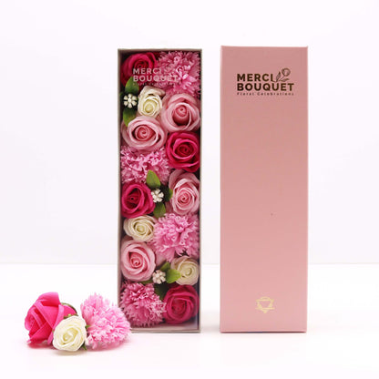 An elegant pink long gift box containing realistic pink soap roses and white flowers, designed as a new baby or baby shower gift.
