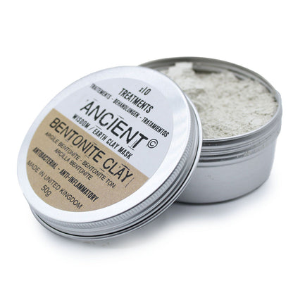 A small round metal tin containing fine, light-grey bentonite clay powder for professional facial masks.