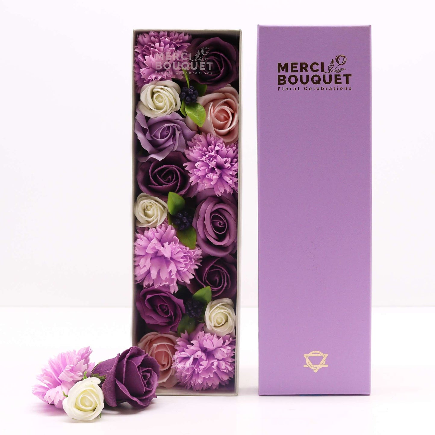 A purple long gift box displaying a beautiful arrangement of realistic lavender soap roses and carnations.