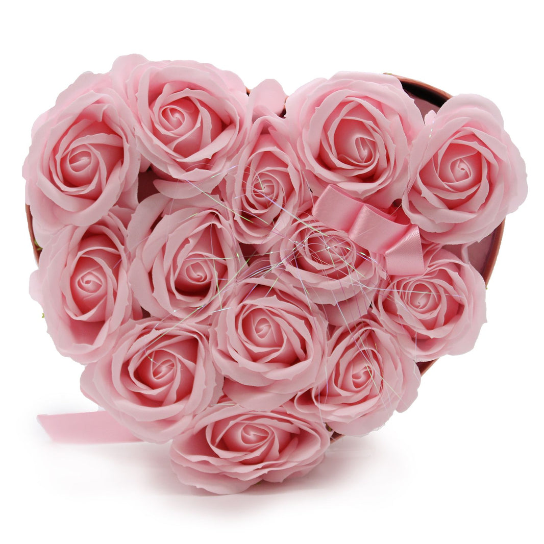 A heart-shaped pink gift box filled with 13 realistic pink soap rose blooms for a romantic bath ritual.