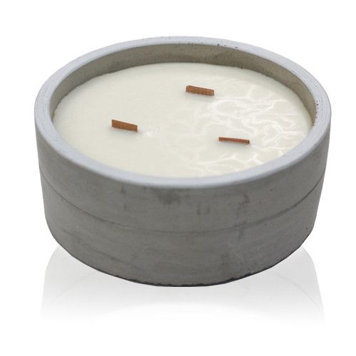 A large, round grey concrete candle pot filled with white soy wax and featuring three wicks for an even burn.