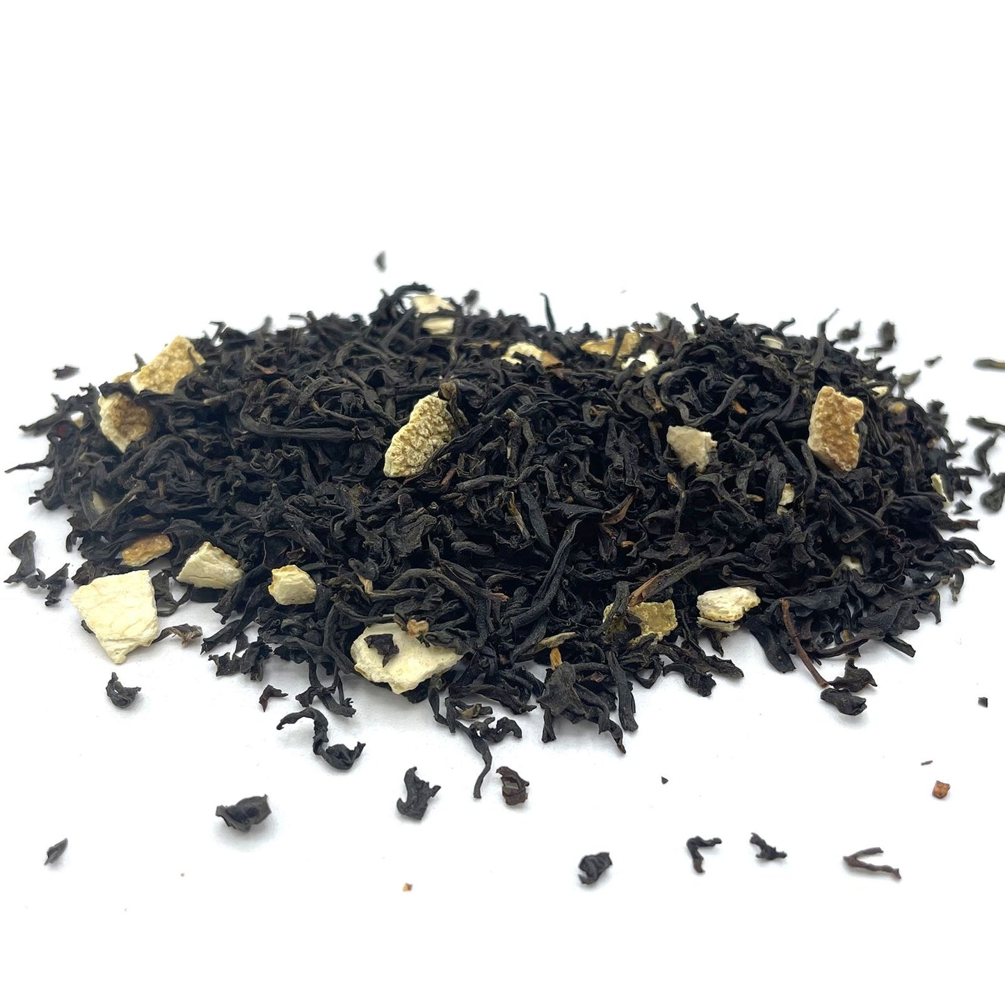 Bulk black loose-leaf tea leaves mixed with bright, dehydrated orange peel pieces and colorful flower petals.