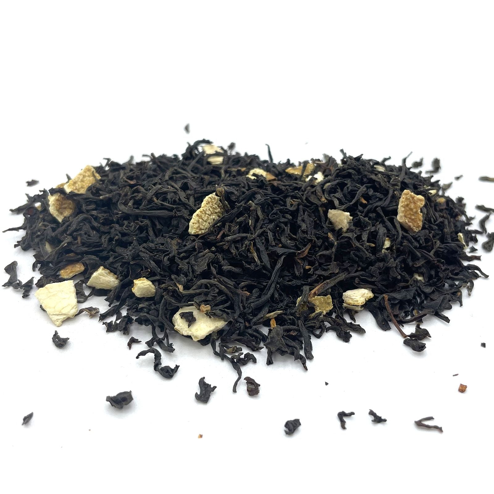 Bulk black loose-leaf tea leaves mixed with bright, dehydrated orange peel pieces and colorful flower petals.