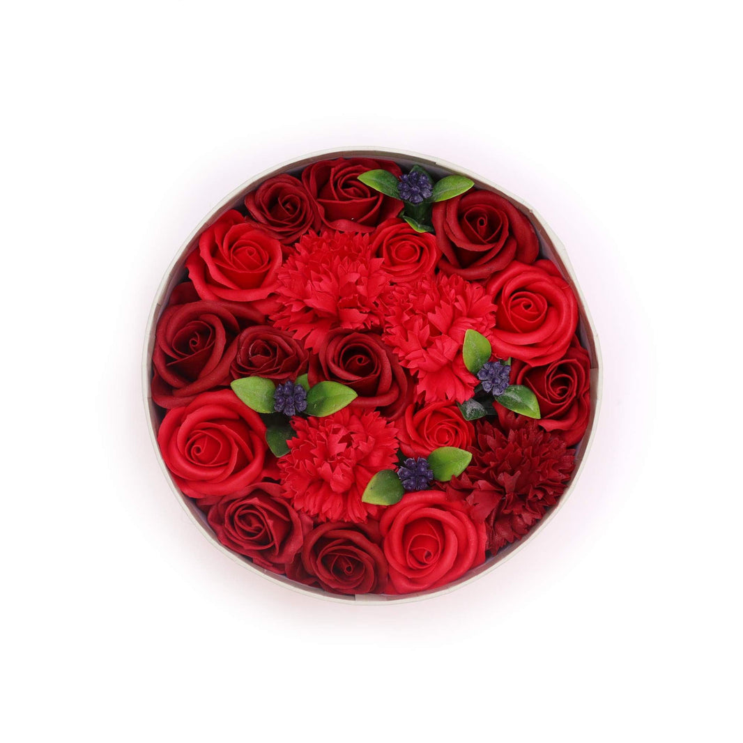 A premium round gift box packed with realistic, deep red soap rose flowers in a classic arrangement.
