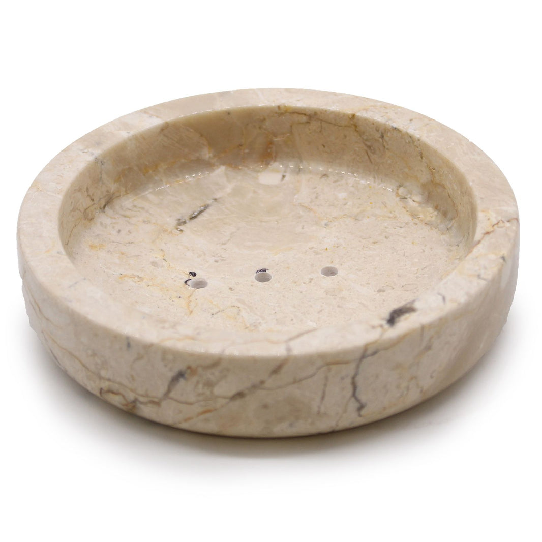 A flat, circular soap dish carved from polished natural honey-toned marble with elegant stone veining.
