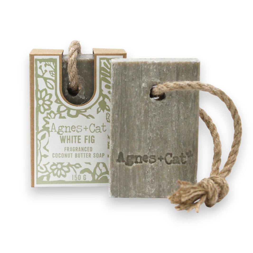 A 150g bar of White Fig scented artisan soap on a natural hanging rope, featured in minimalist earth-toned packaging.