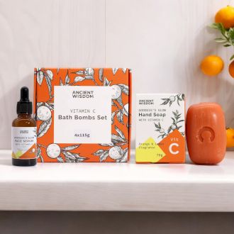A curated gift set featuring a Vitamin C soap bar, bath fizzers, and a matching orange towel in a bright, sun-kissed box.