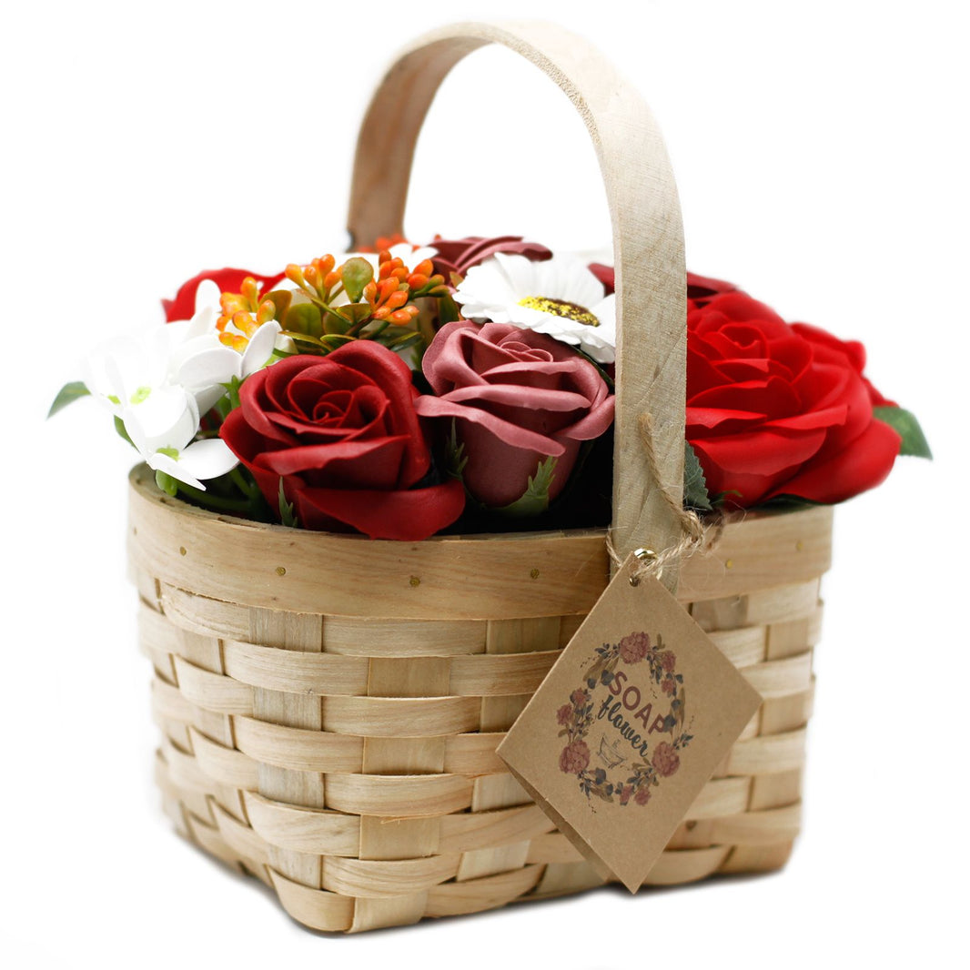 A large, ornate wicker basket overflowing with realistic red soap roses and decorative greenery.