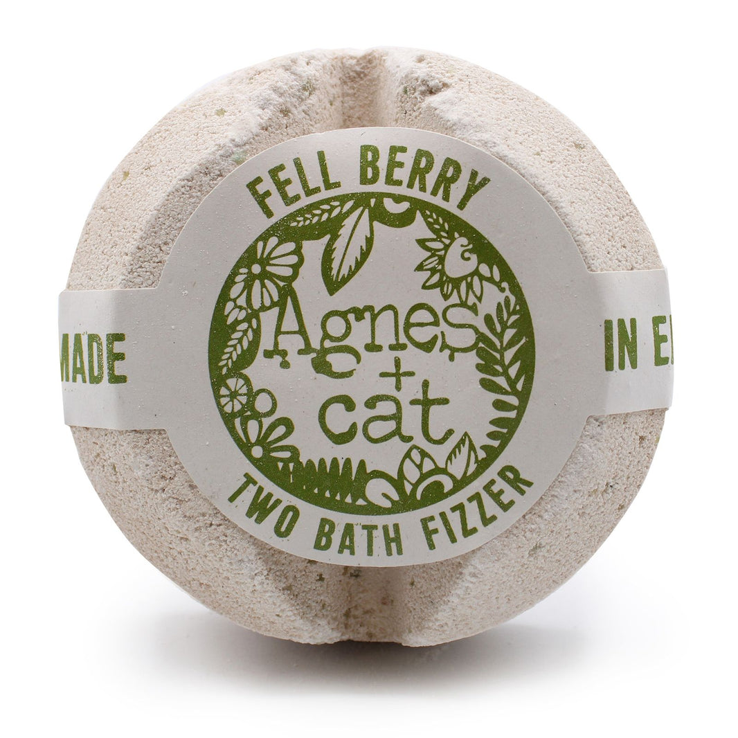 A large spherical bath fizzer with a rustic grey and green label showcasing a unique forest berry design.