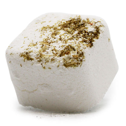 A white square shower steamer tablet topped with real dried green herbs, designed for aromatherapy in the shower.