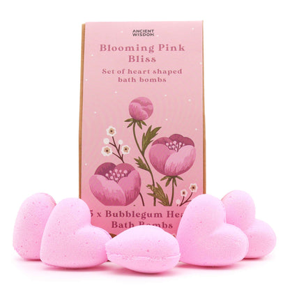 A decorative pink gift box filled with assorted heart-shaped bath bombs and botanical products tied with a pink bow.