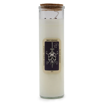 A tall decorative pillar candle labeled "Sweet Revenge" with dark, intricate mystical artwork on the paper wrapping.