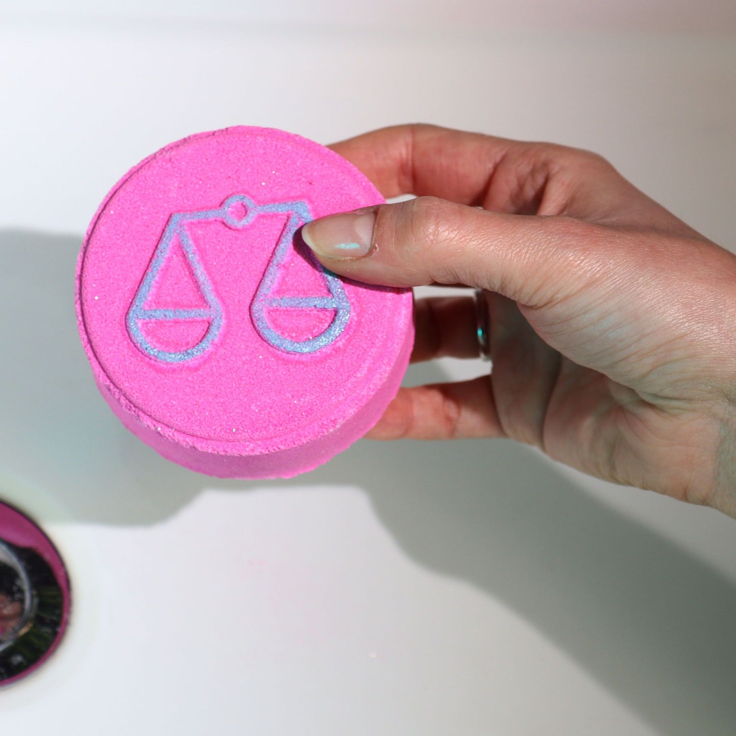A pink-themed set of zodiac bath fizzers for the Libra sign, featuring the libra scales symbol and personalized horoscope info.
