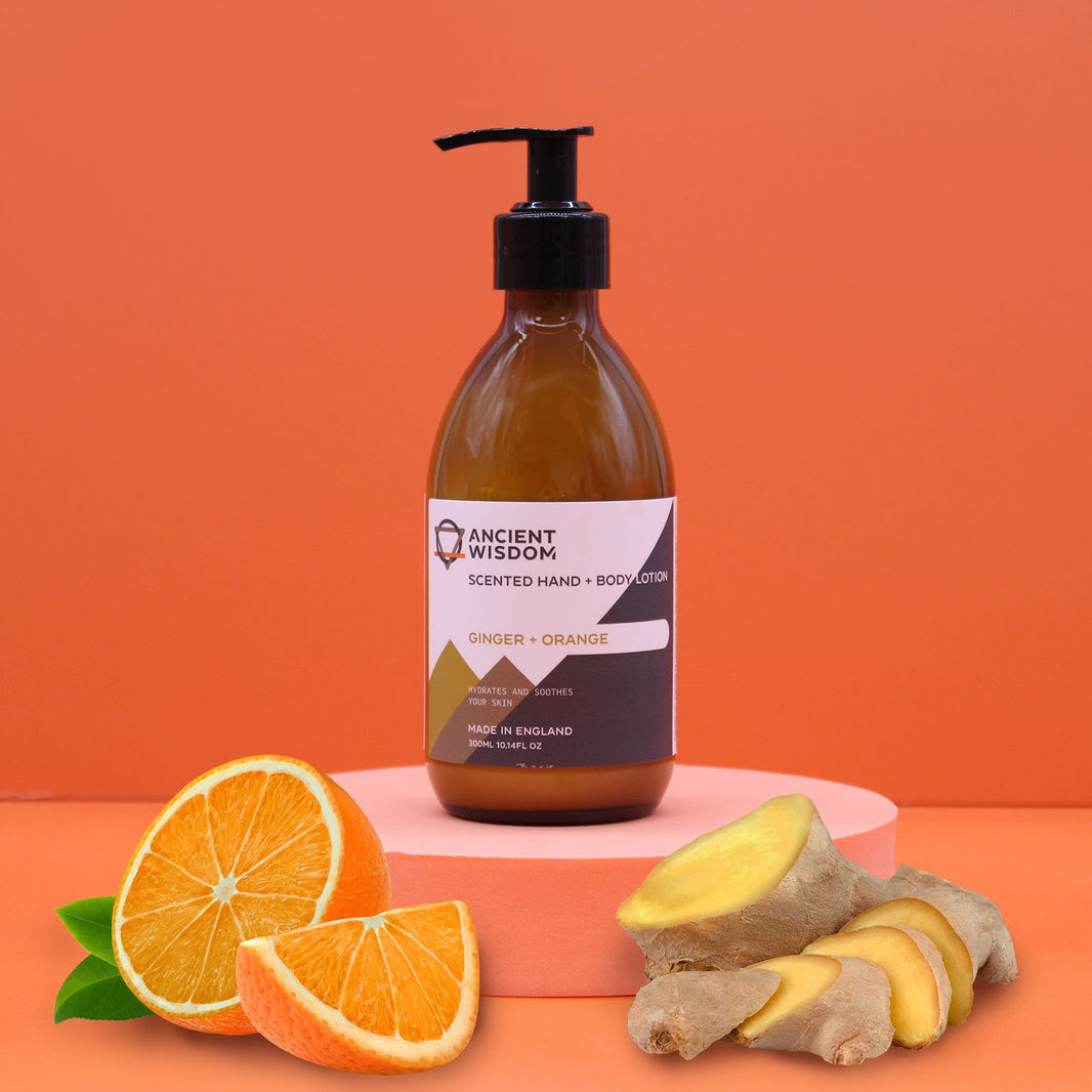 An amber pump bottle of Ginger and Orange body lotion with a professional white and gold label.