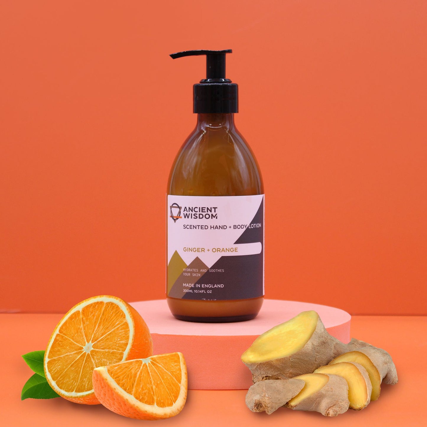 An amber pump bottle of Ginger and Orange body lotion with a professional white and gold label.