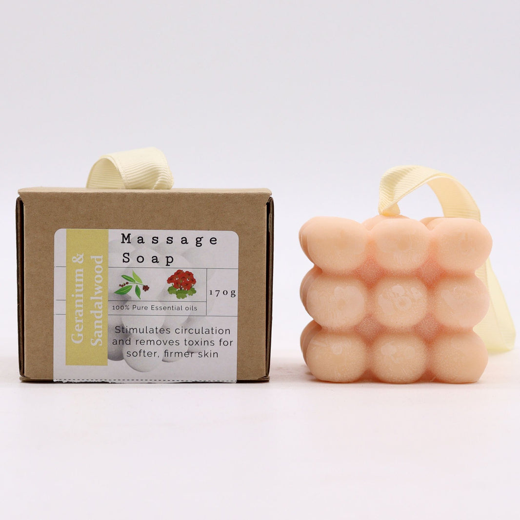 A peach-colored massage soap bar featuring relief nubs for a deep tissue feel, scented with Geranium and Sandalwood.