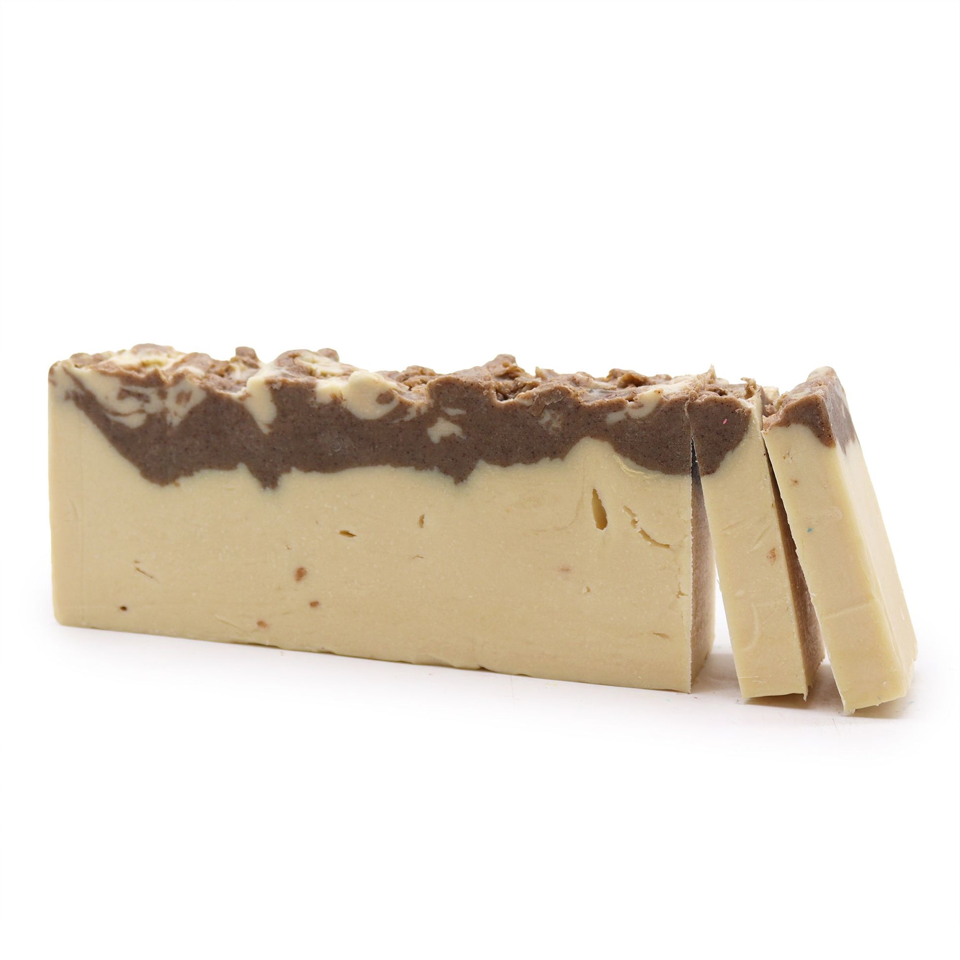 A large, rectangular artisan soap loaf showing a creamy white base and a dark, rustic olive oil-infused top layer.