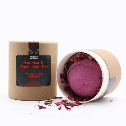 A small gift box containing heart-shaped bath bombs and petals, packaged in a charming round cardboard container with a red bow.