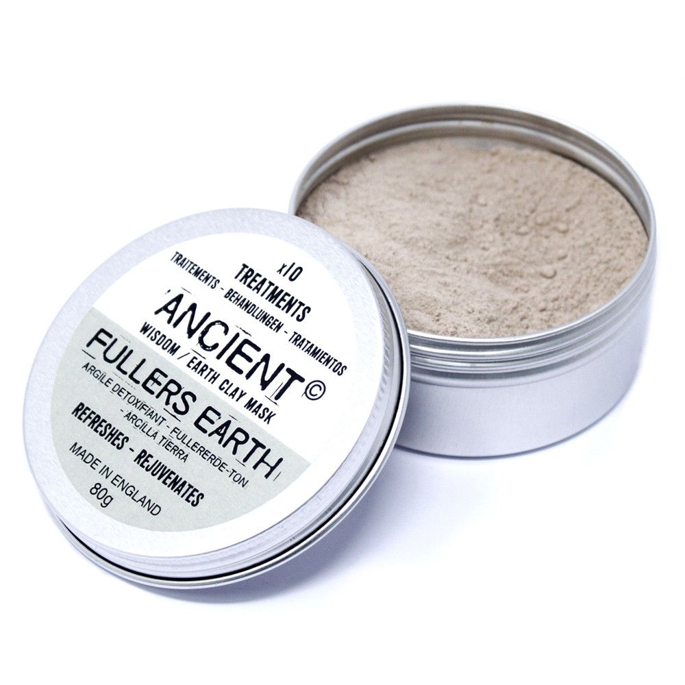 A round metal tin containing fine, grey-toned natural Fuller's Earth clay powder for a detoxifying skincare ritual.
