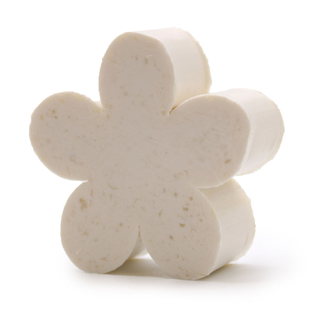 A small, off-white artisanal guest soap bar elegantly carved into a detailed five-petal flower shape.