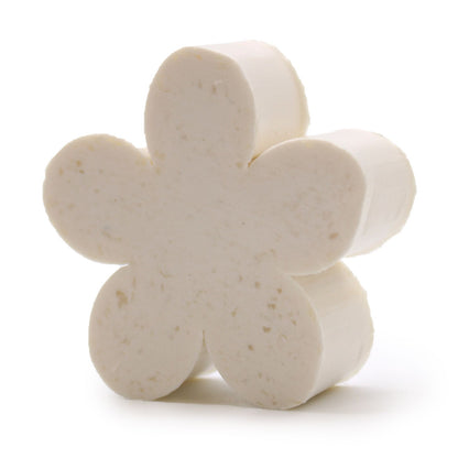 A small, off-white artisanal guest soap bar elegantly carved into a detailed five-petal flower shape.