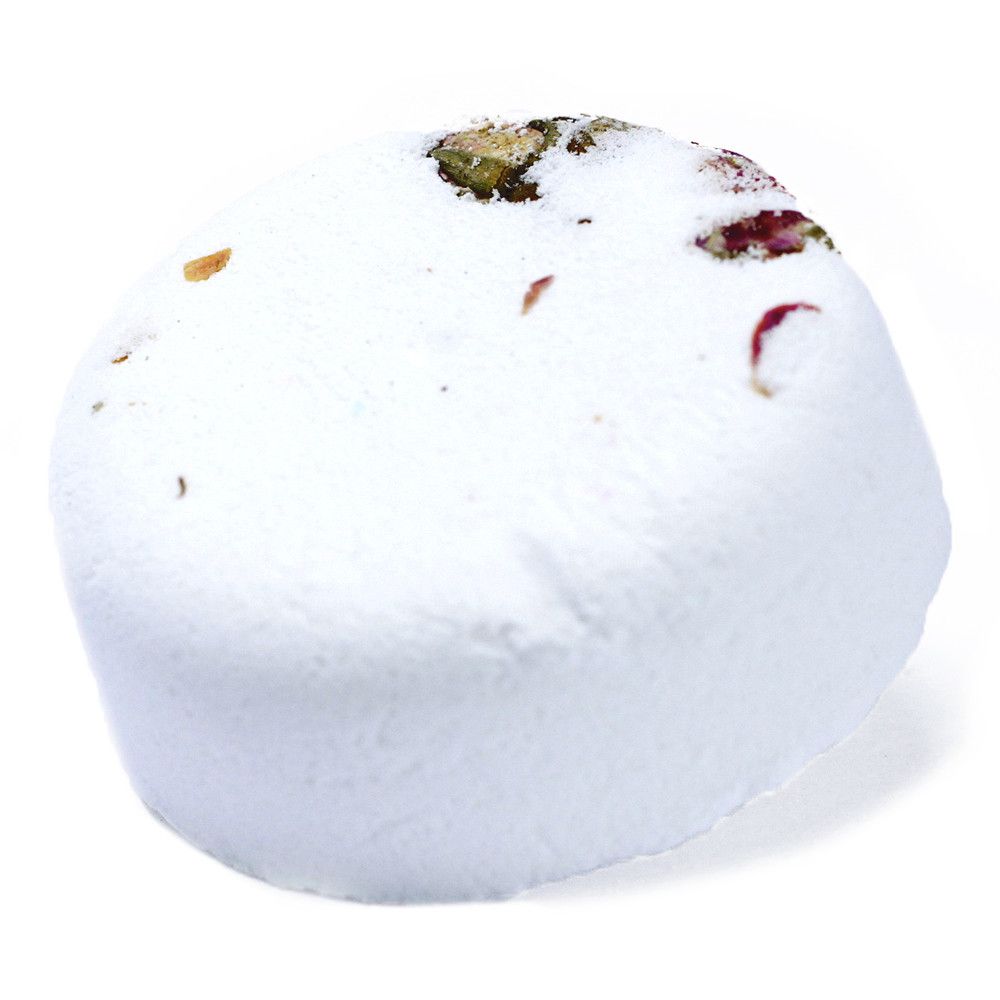 A large white spherical bath bomb decorated with real dried botanical petals and herbs on the top.