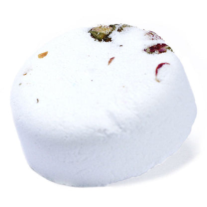 A large white spherical bath bomb decorated with real dried botanical petals and herbs on the top.