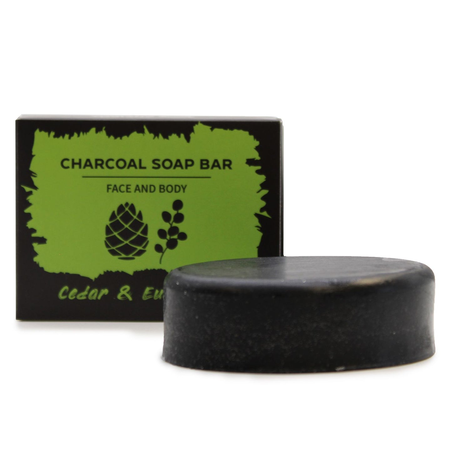 A sleek black charcoal soap bar packaged in a dark-themed artisan box with green herbal and wood-grain illustrations.