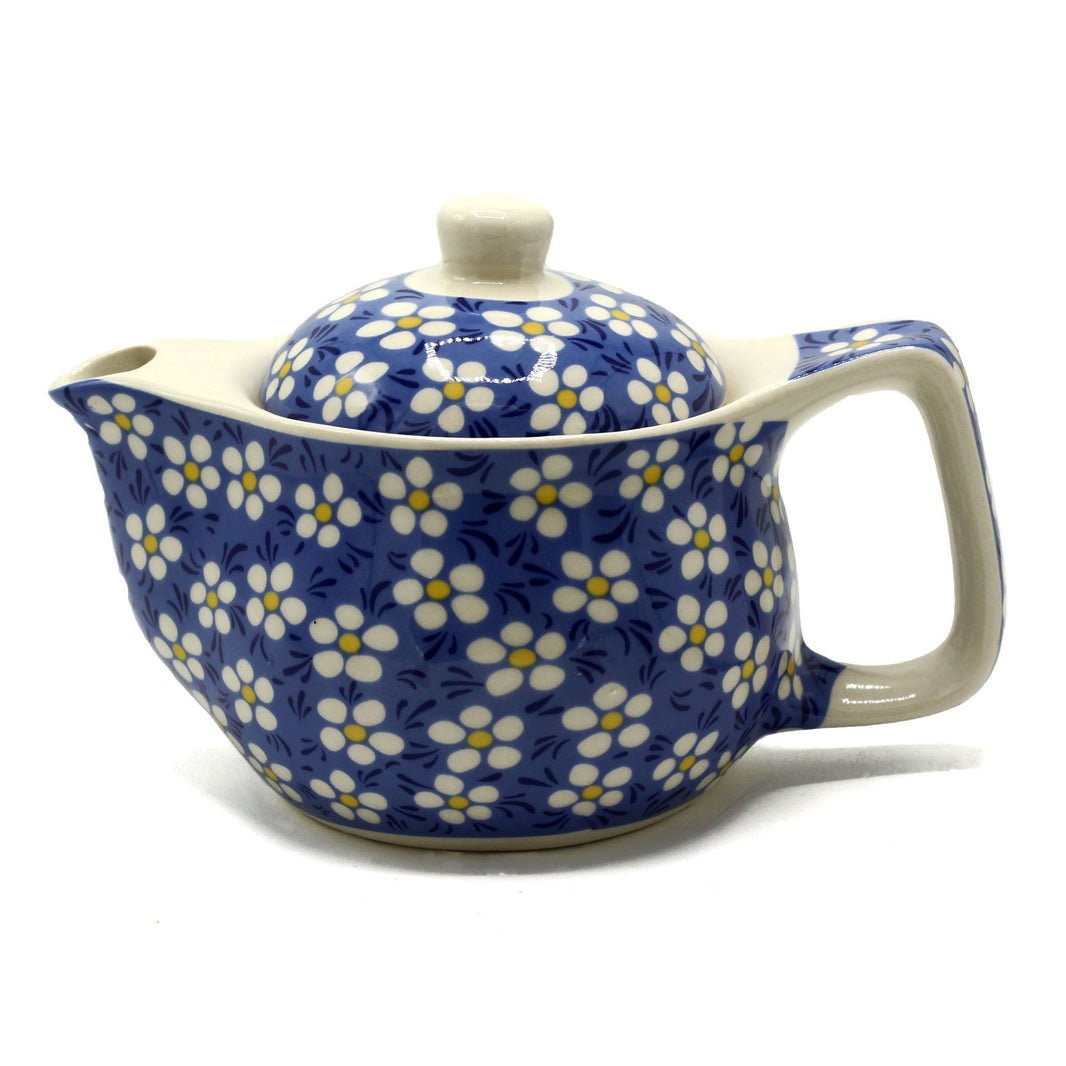 A small white ceramic teapot decorated with a blue background and white daisy flower patterns.