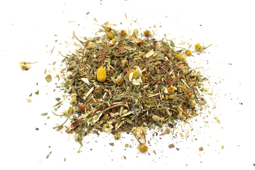 A high-volume quantity of loose herbal tea featuring dried botanicals, green leaves, and golden flower petals.