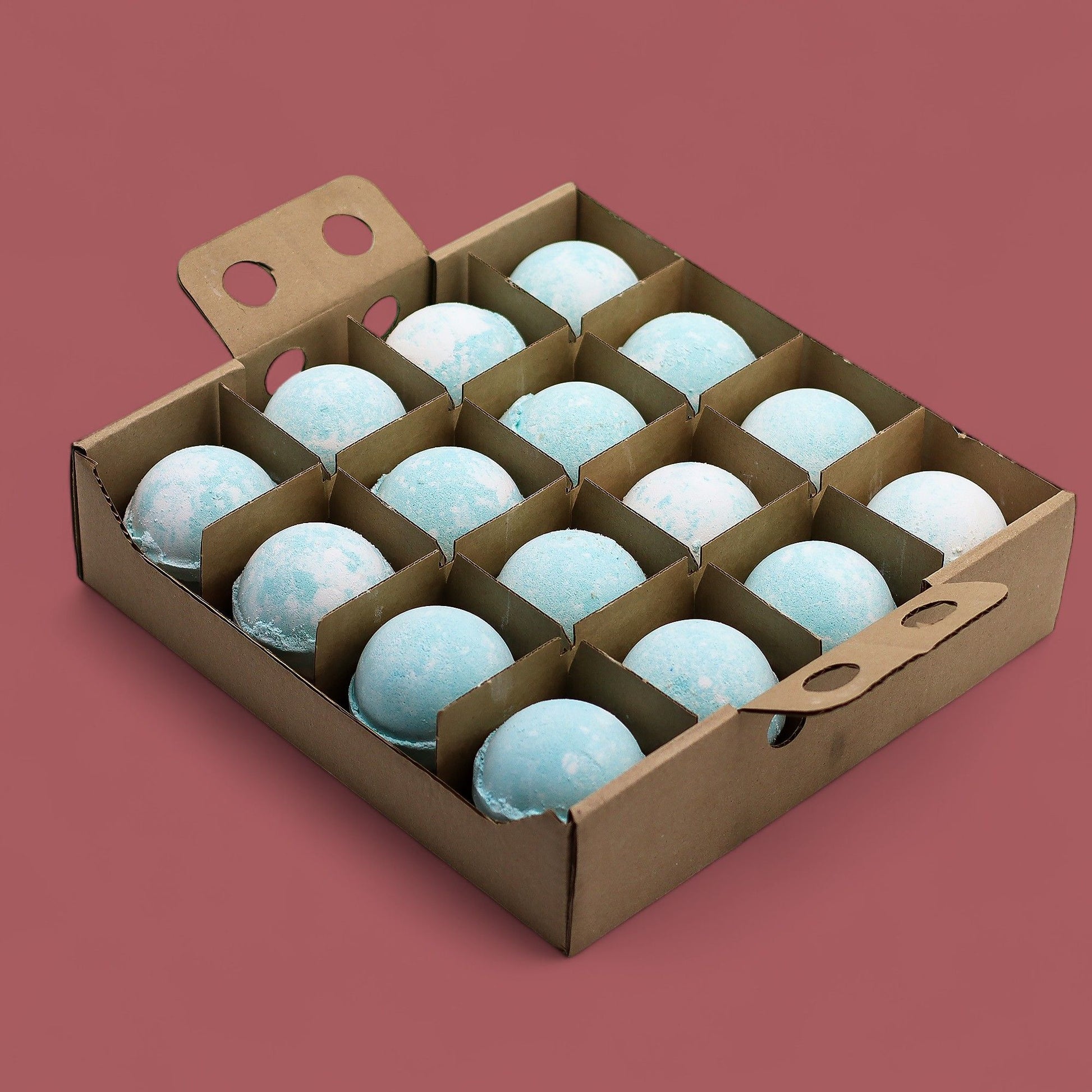 A large cardboard display tray containing sixteen individually wrapped blue and grey bath bombs designed for men.