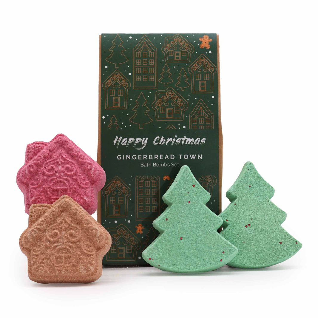 A festive holiday gift box containing three gingerbread-themed bath bombs shaped like a house and Christmas trees.