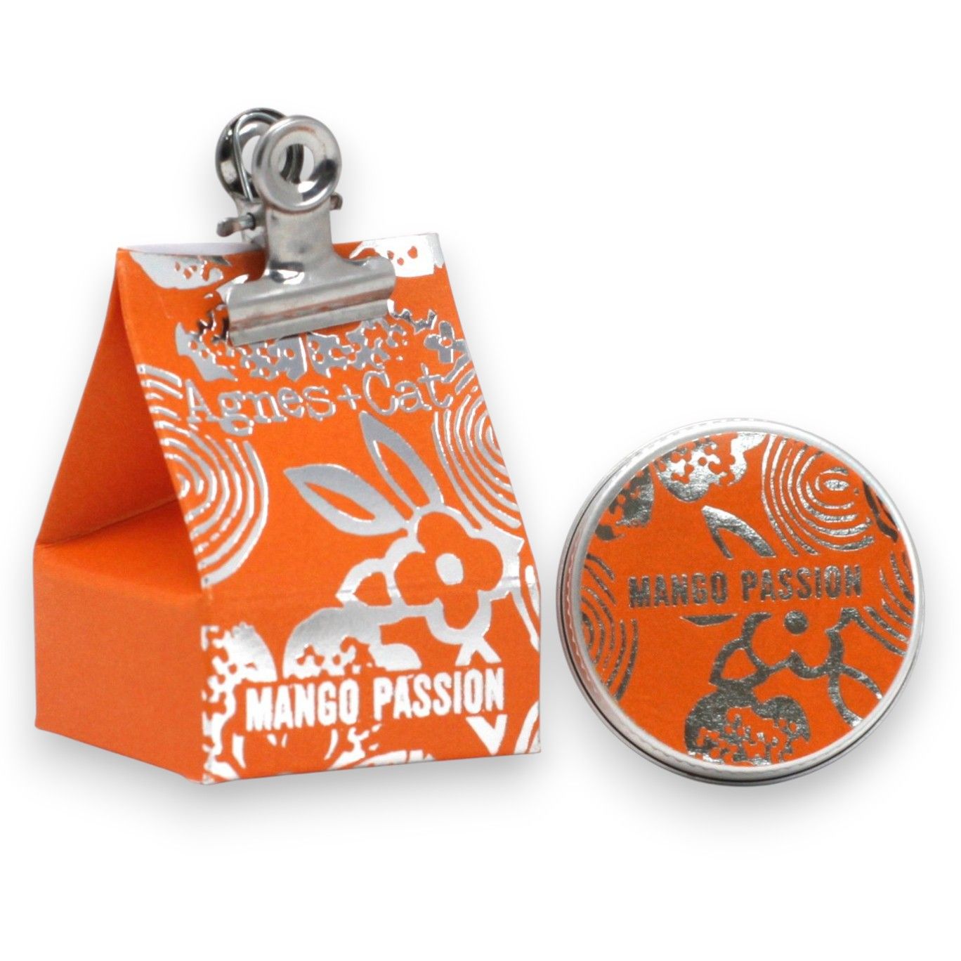 A 20g round tin of Mango and Passion Fruit scented lip balm with bright orange-themed gift packaging.