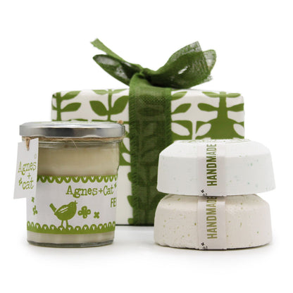 A luxury spa gift box containing a Rhubarb scented candle and two large artisan bath fizzers, tied with a decorative bow.