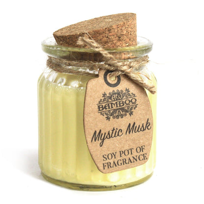 A small clear glass candle pot with pale yellow soy wax, a natural cork lid, and a twine-wrapped label.