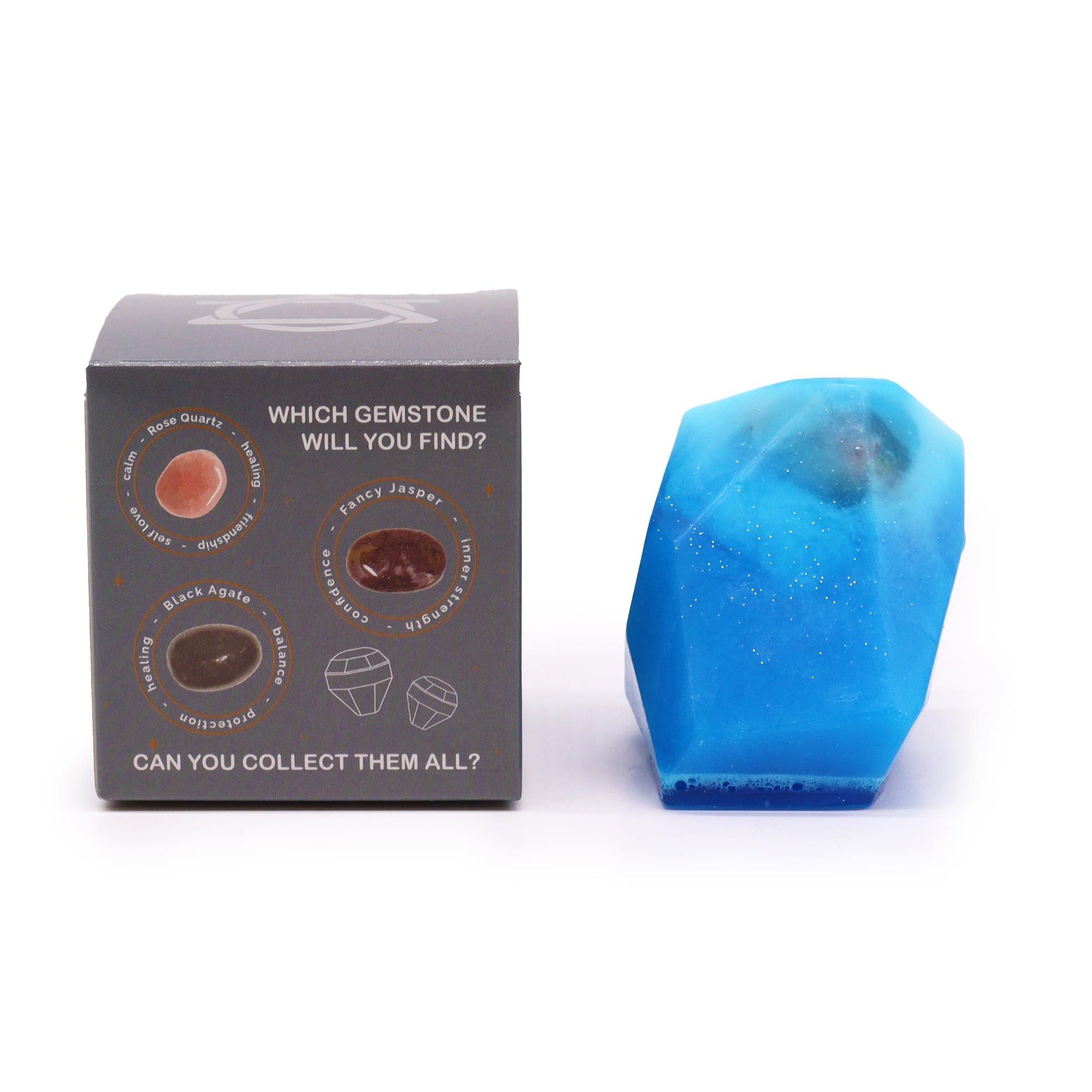 A translucent blue artisan soap bar shaped like a rough-cut crystal gemstone, packaged in a themed black box.