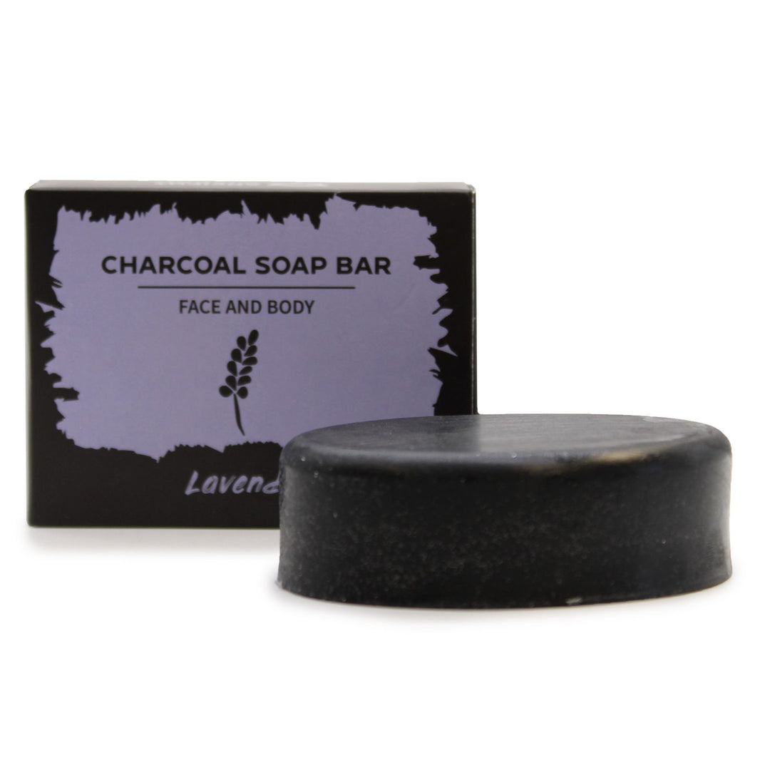 A sleek, rectangular black charcoal soap bar packaged in a dark-themed artisan box with delicate lavender illustrations.