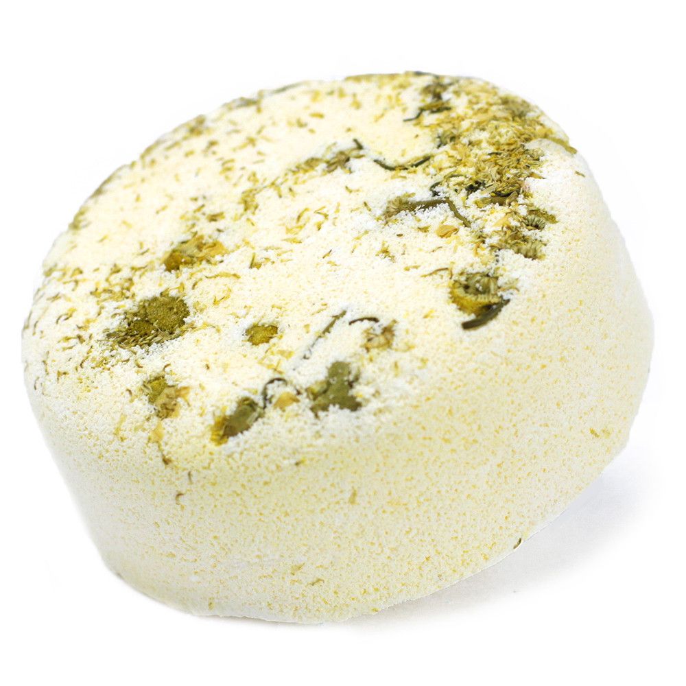 A creamy white bath bomb embedded with an assortment of green dried herbs and natural botanical inclusions.