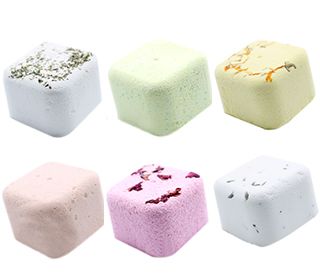 A small gift box displaying colorful heart and square-shaped shower steamers infused with therapeutic essential oils.