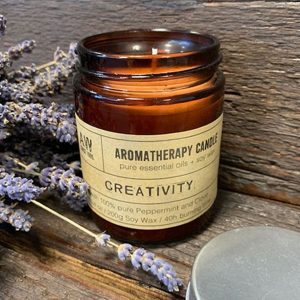 A 200g aromatherapy soy candle in an amber glass jar with a black lid, designed for creativity and mental flow.