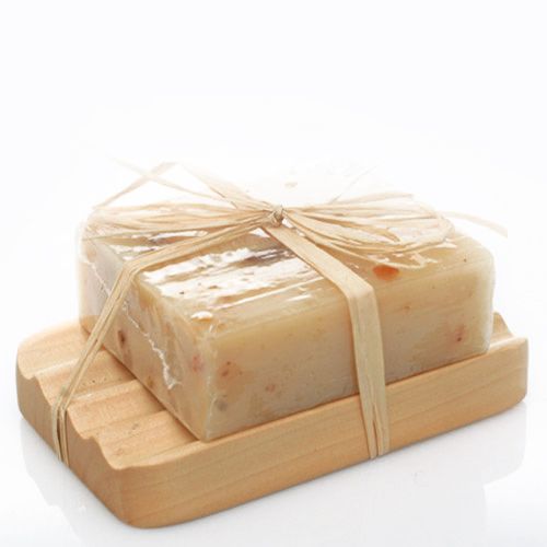 A wavy, natural light-toned Hemu wood soap dish with a "groovy" curved design for drainage.